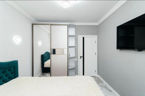 a bedroom with a bed and a tv on a wall at Apartament in Chişinău