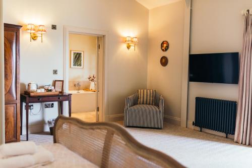 a living room with a television and a chair at Nest Farmhouse in Docking