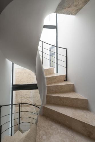 a spiral staircase in a house with a glass railing at The Bear and Ween in St Julian's
