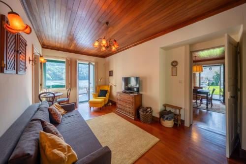 a living room with a couch and a tv at Feel Discovery Casa do Rio Douro Valley in Riba Douro