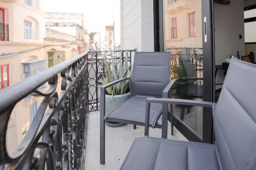 a balcony with two chairs on a balcony at The Bear and Ween in St Julian's