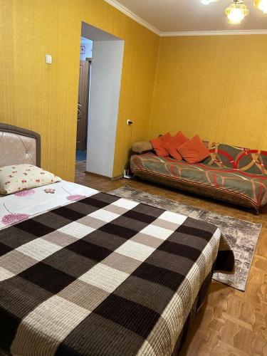 a bedroom with a bed and a couch in it at Economy - class apartment in Pavlodar