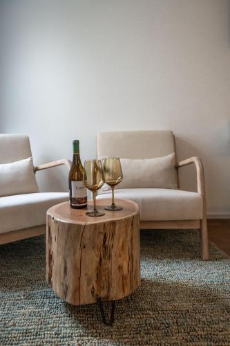 a bottle of wine and two wine glasses on a coffee table at The Bear and Ween in St Julian's