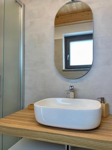 a bathroom with a white sink and a mirror at Cascina Ricardin in Coazzolo