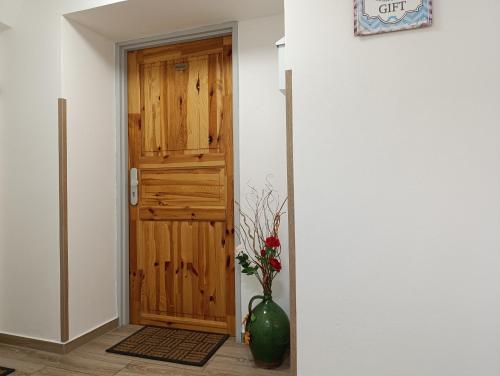 a hallway with a wooden door and a vase with flowers at U Bocmana s výhledem na zámek a Labe in Děčín