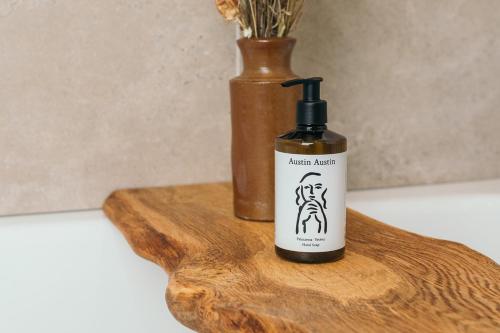 a bottle of alcohol sitting on a wooden cutting board at Nest Farmhouse in Docking