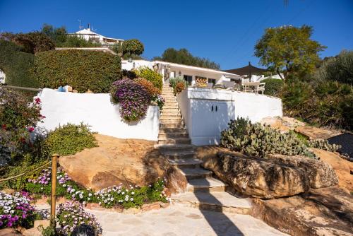 a set of stairs leading up to a house with flowers at Finca Gran Cerros in Alora