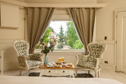a living room with two chairs and a table and a window at Hotel Casablanca Spa & Wine in Casablanca