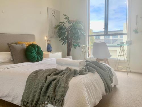 una camera da letto con un letto con una coperta verde sopra di Stellar Suite a Woodville South