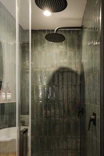 a bathroom with a shower with green tiled walls at The Bear and Ween in St Julian's