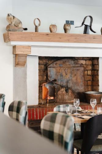 a fireplace with a table and chairs in front of it at Hostellerie du Petit Saint Bernard in Bourg-Saint-Maurice
