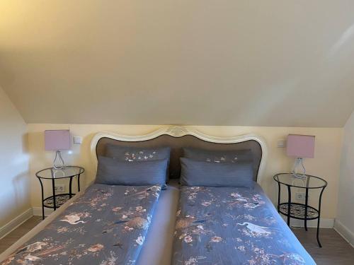 a bedroom with a bed with two lamps on both sides at Hotel Deichvoigt in Cuxhaven
