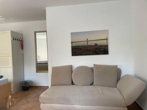 a living room with a couch and a mirror at Hotel Deichvoigt in Cuxhaven