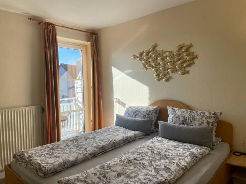 a bed in a room with a window at Hotel Deichvoigt in Cuxhaven