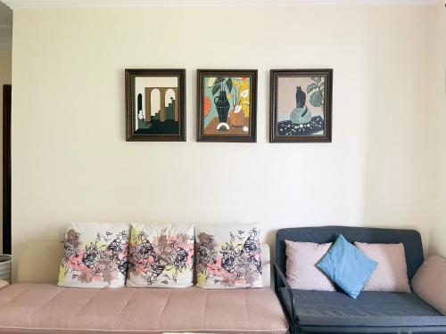 a living room with a couch and four pictures on the wall at Dory Home B&B-Nanning-Ladies only in Nanning