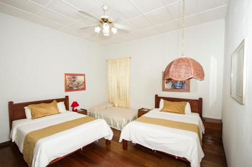 a bedroom with two beds and a ceiling fan at Hotel 1492 in San José