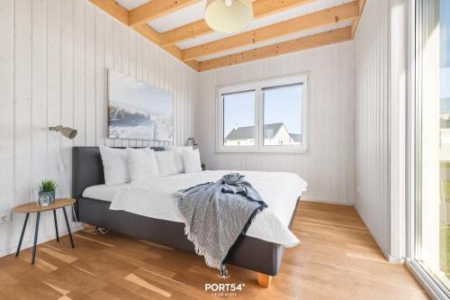 a bedroom with a large bed in a white room at Ferienhaus Olpi Olpenitz in Olpenitz