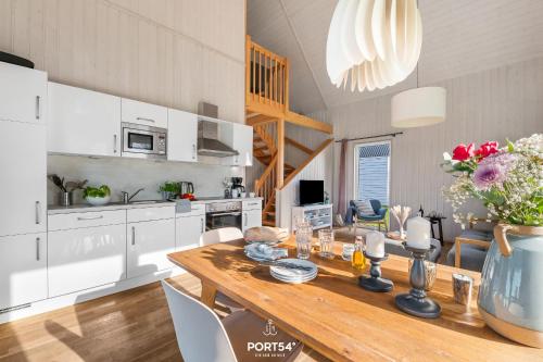 a kitchen with a wooden table and white cabinets at Ferienhaus Olpi Olpenitz in Olpenitz