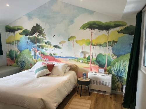 a bedroom with a mural of trees and bushes at Chambre d'Hôtes Etchebri in Anglet