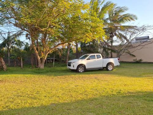 a white car parked in a yard next to a tree at CapNature in Saint-André