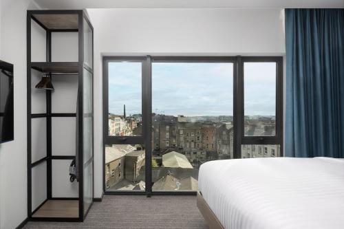 a hotel room with a bed and a large window at Residence Inn by Marriott Cork in Cork