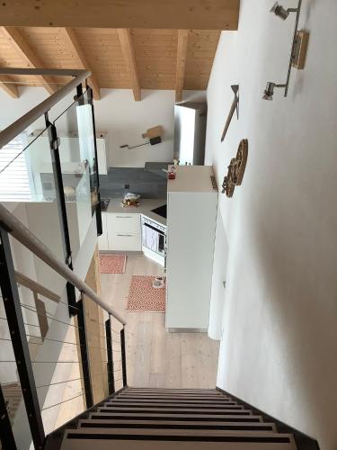 a staircase leading to a kitchen with a white refrigerator at Tga Pilu in Parsonz