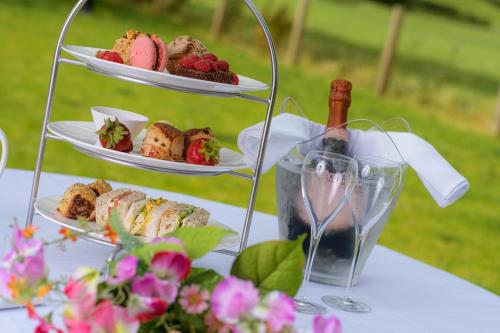 a table with two plates of food and a bottle of wine at The Old Gables in Brampton