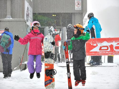 a group of people standing in the snow with snowboards at Chalet Apartments - Mt Buller Apartment Rentals in Mount Buller