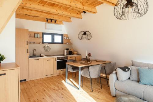 a kitchen and living room with a table and a couch at SunMoon Kosmaj kućice i prostor za događaje in Sopot