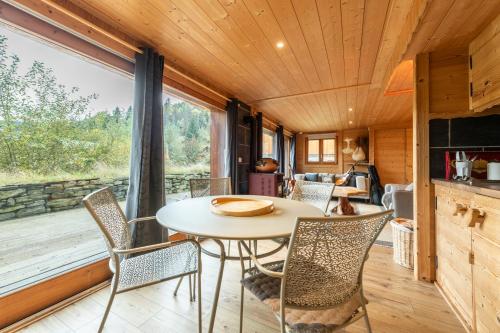 - une salle à manger avec une table et des chaises dans une petite maison dans l'établissement Chalet Le Moulin des Neiges - Solliet, à Montvalezan