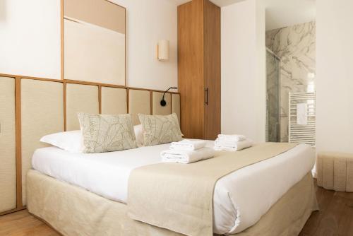 une chambre avec un grand lit blanc avec des serviettes dessus dans l'établissement Modern apartment 2BR-6P - Jardin de Luxembourg, à Paris
