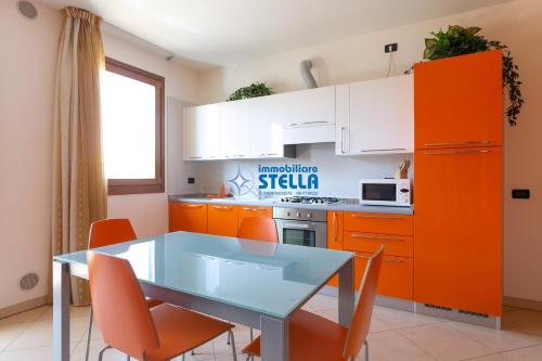 a kitchen with orange cabinets and a table and chairs at Archimede in Lido di Jesolo