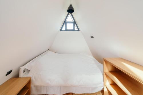 a bedroom with a white bed in a loft at SunMoon Kosmaj kućice i prostor za događaje in Sopot