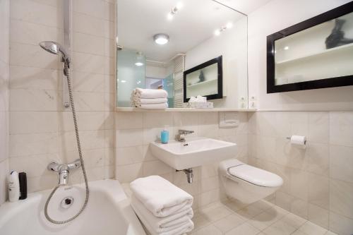 a white bathroom with a sink and a toilet at City Central Ljubljana in Ljubljana