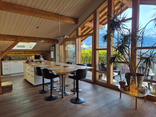 une cuisine avec une grande table et des chaises en bois dans l'établissement Le nid montagnard - Vulmix, à Bourg-Saint-Maurice