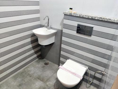 une salle de bains avec toilettes et lavabo dans l'établissement Shree Ji Stays, à Fāzilka