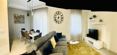 a living room with a couch and a table and a clock at Stylish 2 Bedrooms apartment in Gzira in Il-Gżira