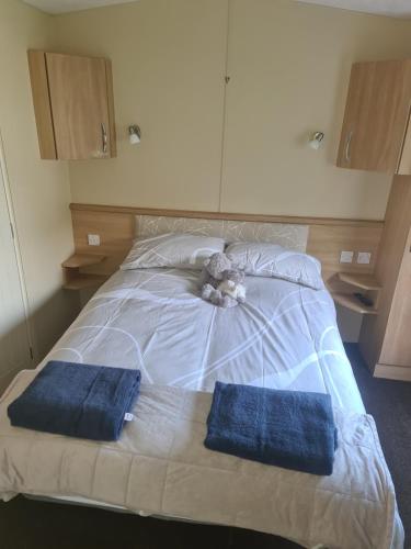 a bed with two towels and a teddy bear on it at Fern Lodge Holiday Lets presents Kelly's Lodge in West Thirston