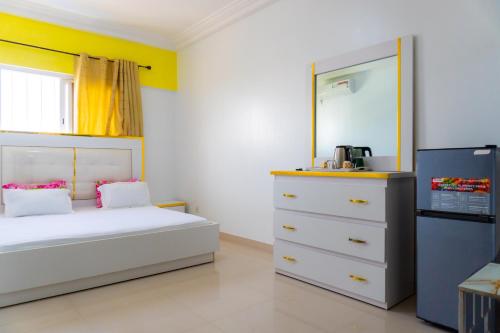 a bedroom with a white bed and a dresser at Chambres meublées Avenue Cheikh Anta Diop in Dakar