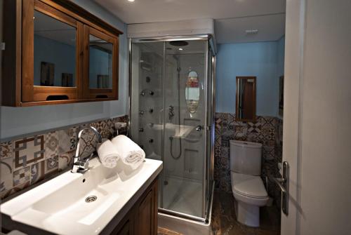 Un baño con ducha, lavabo e inodoro. en Casa Rural Gite El Tossal, en Collfred