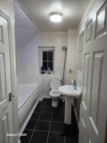 a bathroom with a sink and a toilet and a bath tub at 69 swan lane in Coventry