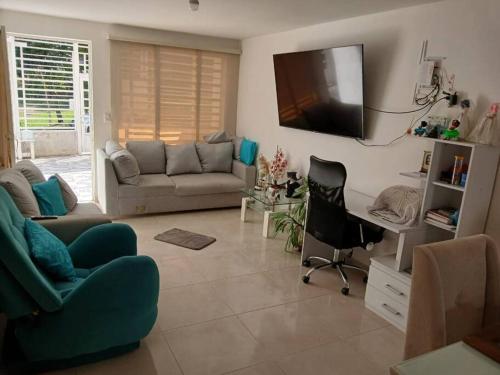 a living room with a couch and a tv on the wall at Espectacular Casa en Barbosa Santander in Barbosa