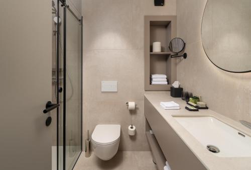 a bathroom with a toilet and a sink and a shower at Molum Hotel & Residences in Sveti Filip i Jakov