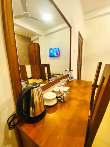 a wooden table with a tea kettle on top of it at Hotel Rosenro in Piliyandala