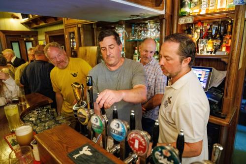 a group of men standing at a bar at Stoneyford Luxurious Cabins in Stonyford