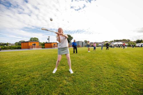 a woman swinging a baseball bat at a ball at Stoneyford Luxurious Cabins in Stonyford