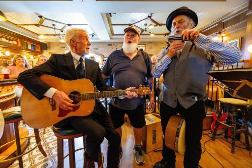 a group of three men playing a guitar at Stoneyford Luxurious Cabins in Stonyford