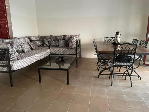 a living room with a couch and a table and chairs at Maison de campagne à Sipo in Sipo