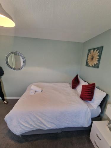 a bedroom with a large white bed with red pillows at 51 Lenham House in Sutton