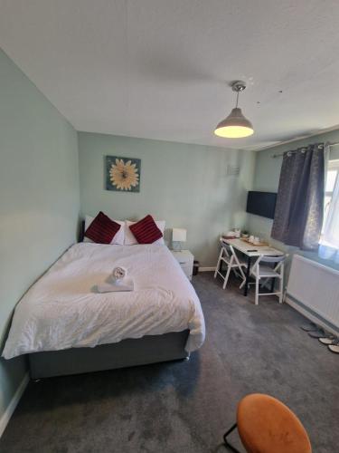 a bedroom with a bed with a clock on the wall at 51 Lenham House in Sutton